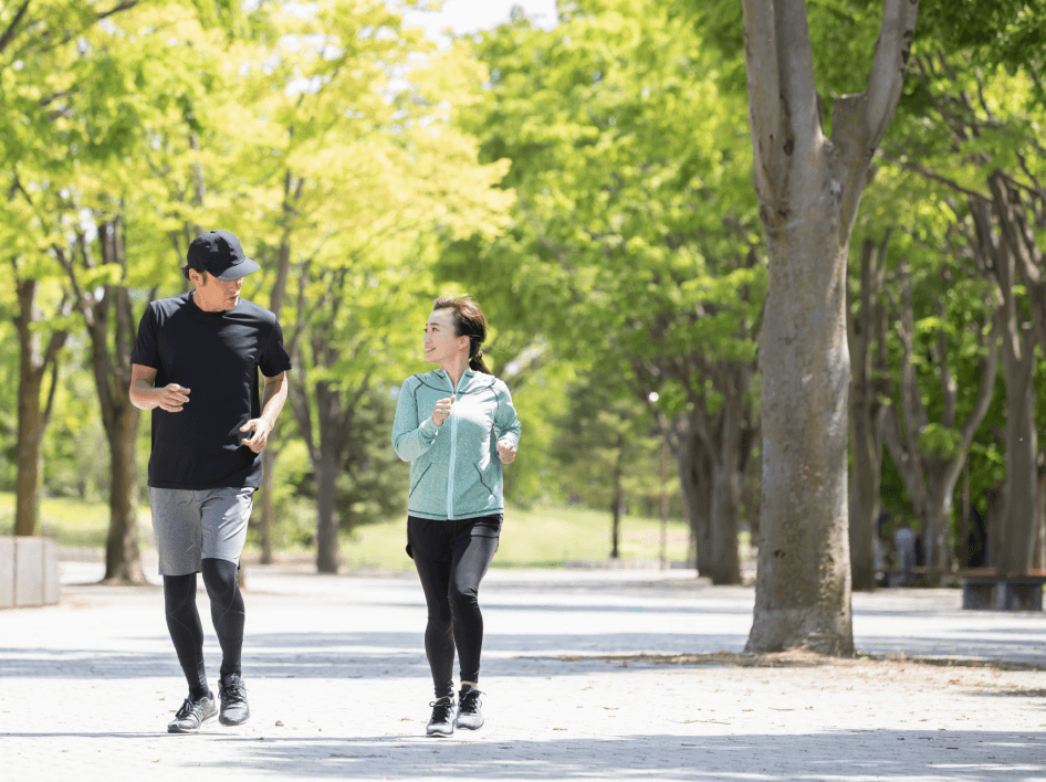 男性と女性が公園をジョギングしている画像